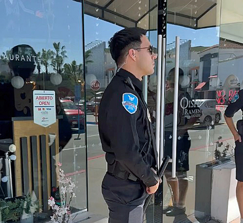 ACS security guards monitor store entrances.